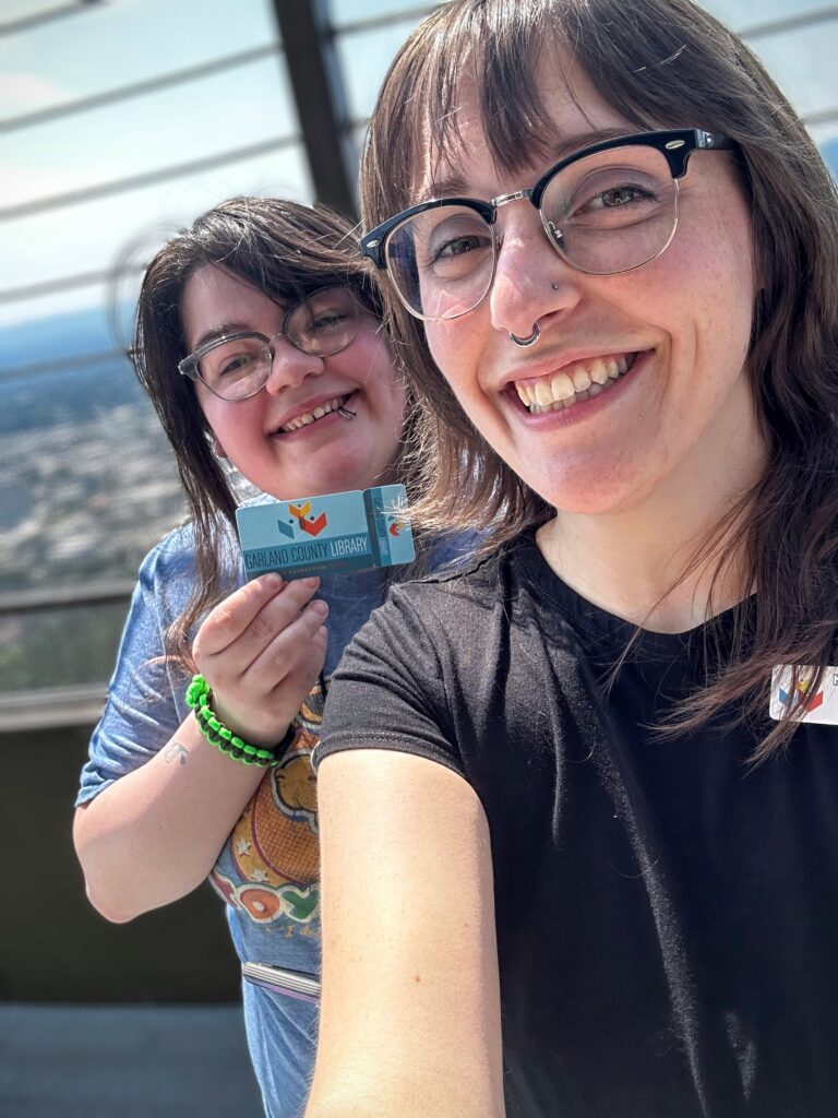 Winter and Jessamyn hold up a library card