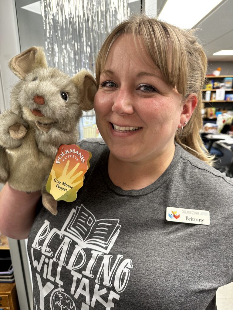 Teen Librarian, Brittany, holds a puppet.