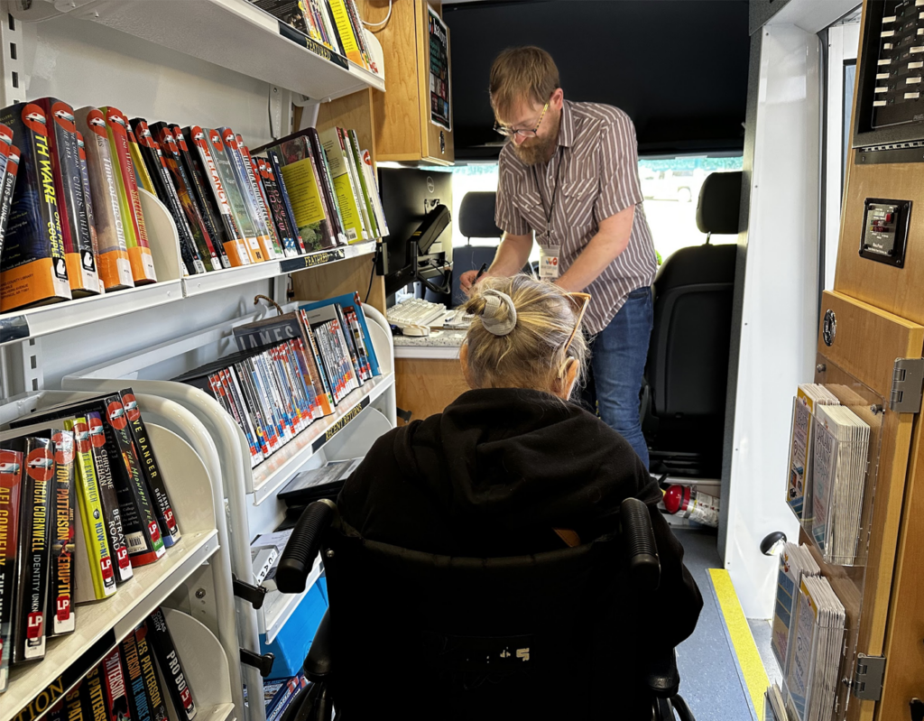 Staff and patron inside the GCL bookmobile.